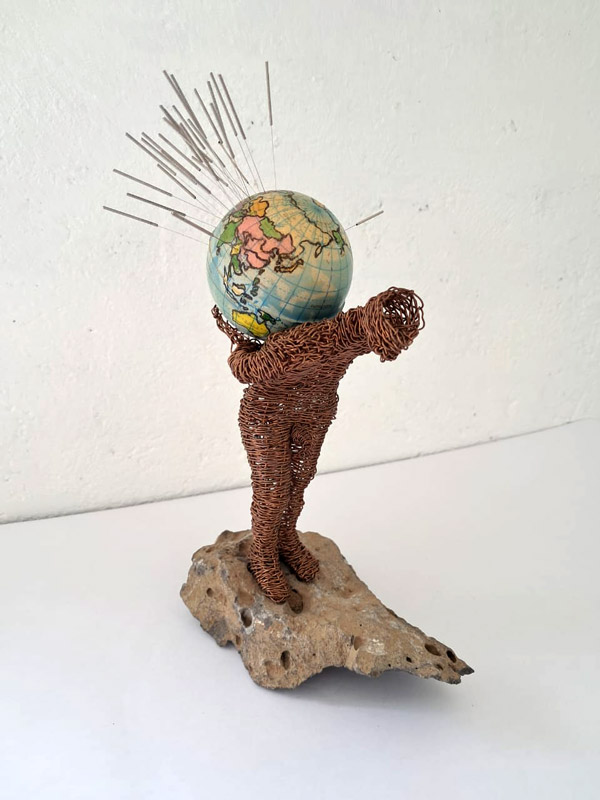 <p><em>La punzante realidad</em>. 25X9X16 cm. Piedra, alambre de cobre tejido a mano, pelota de hule con mapamundi, agujas de acupuntura, 2021</p>
